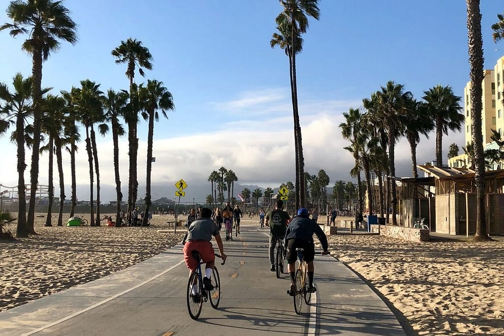 The famous Vencie Beach bike path with a couple of cyclists cruisng by