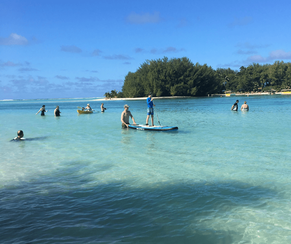 Everyone relaxing in Muri Lagoon Rarotonga, a mix on swimming, floating, paddle boarding and kayaking