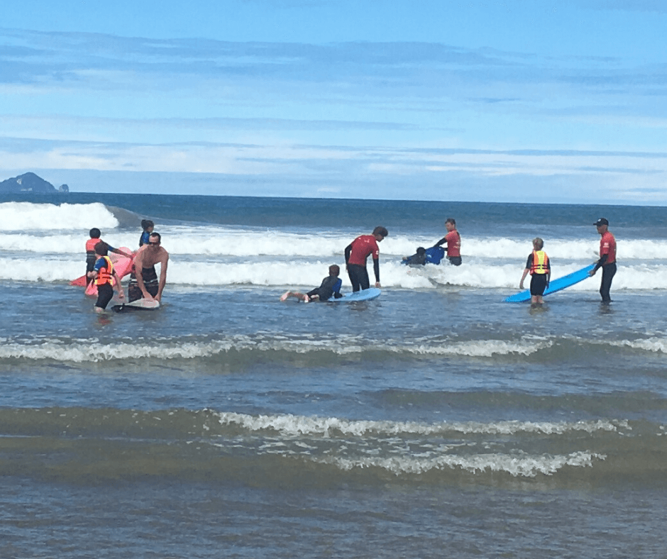Surf instructors with a group of kids ready to catch a wave