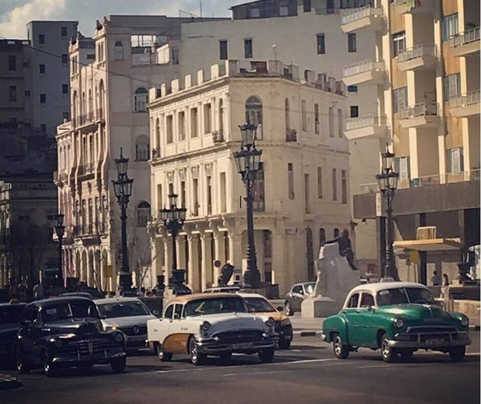 Vintage Cars waiting at the lights with stunning old buildings as the back drop