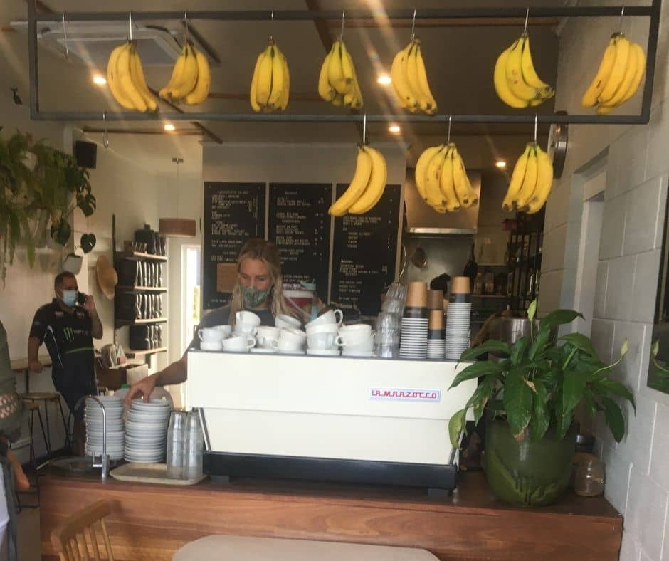 Bananas hanging from the ceiling while coffee is being prepared