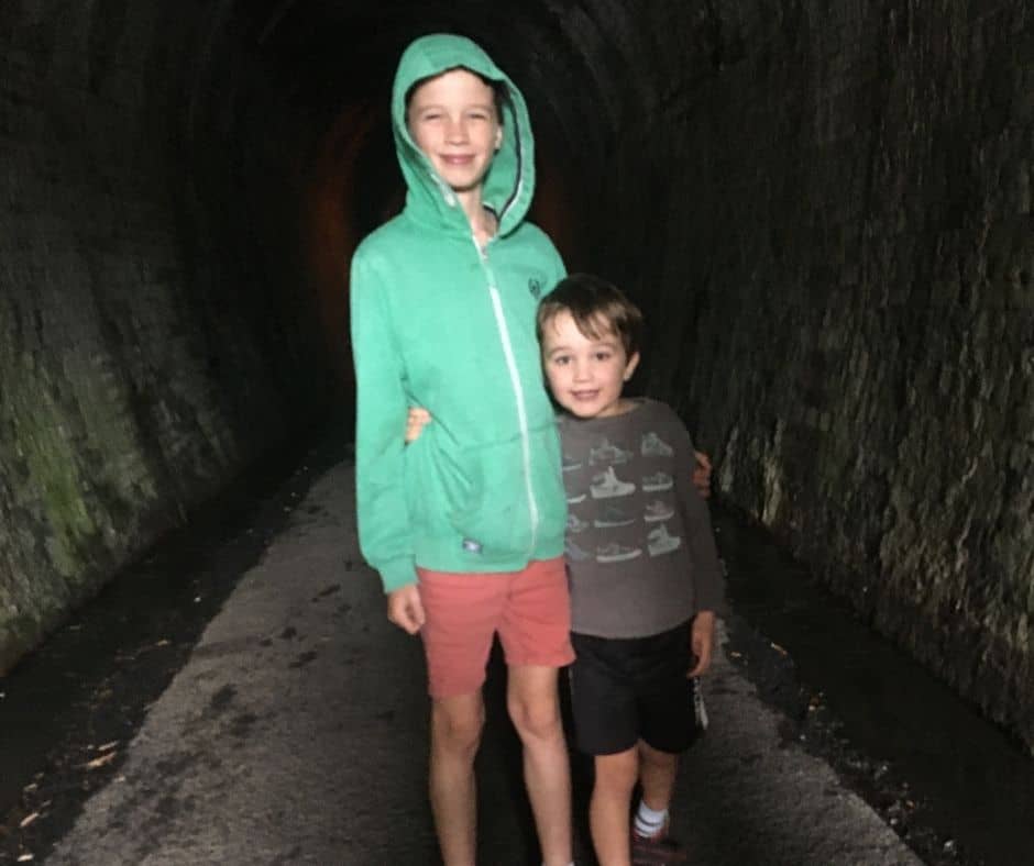 The boys standing for a photo in the middle of the old railway tunnel
